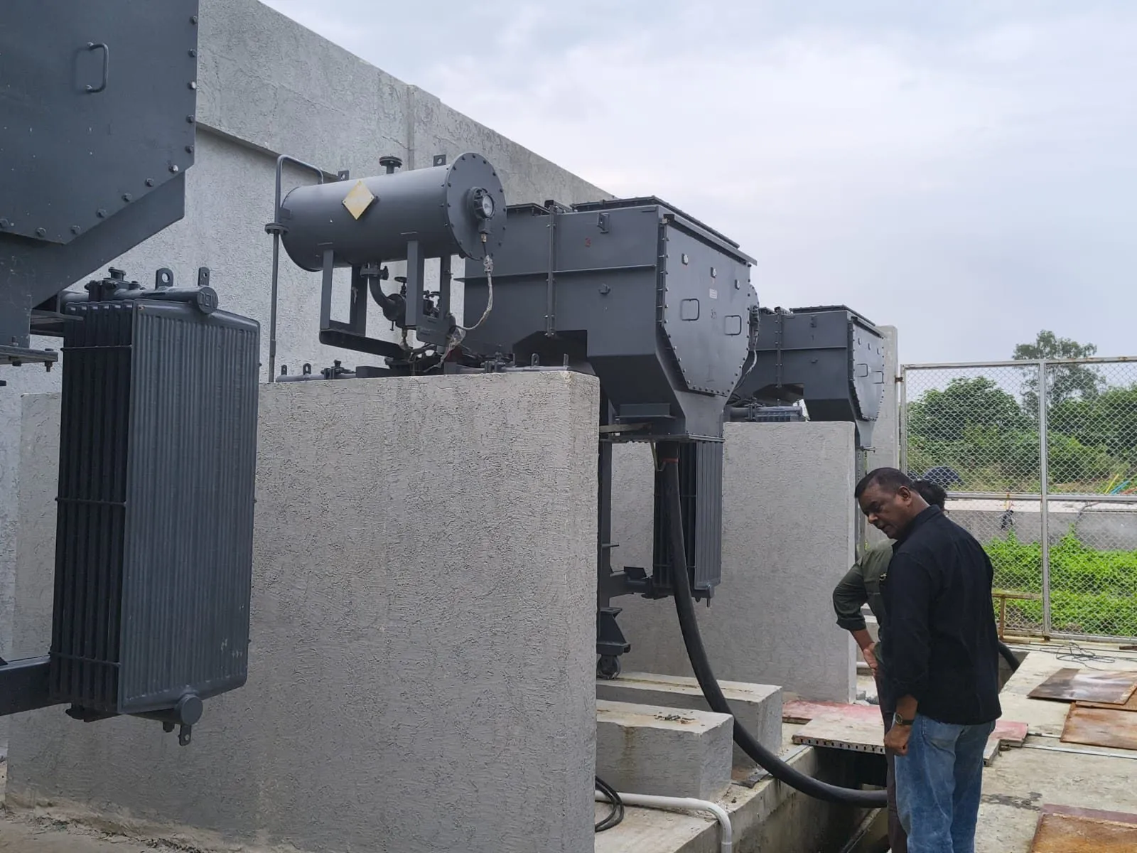 Ranisons engineer checking connections at the base of an installed transformer