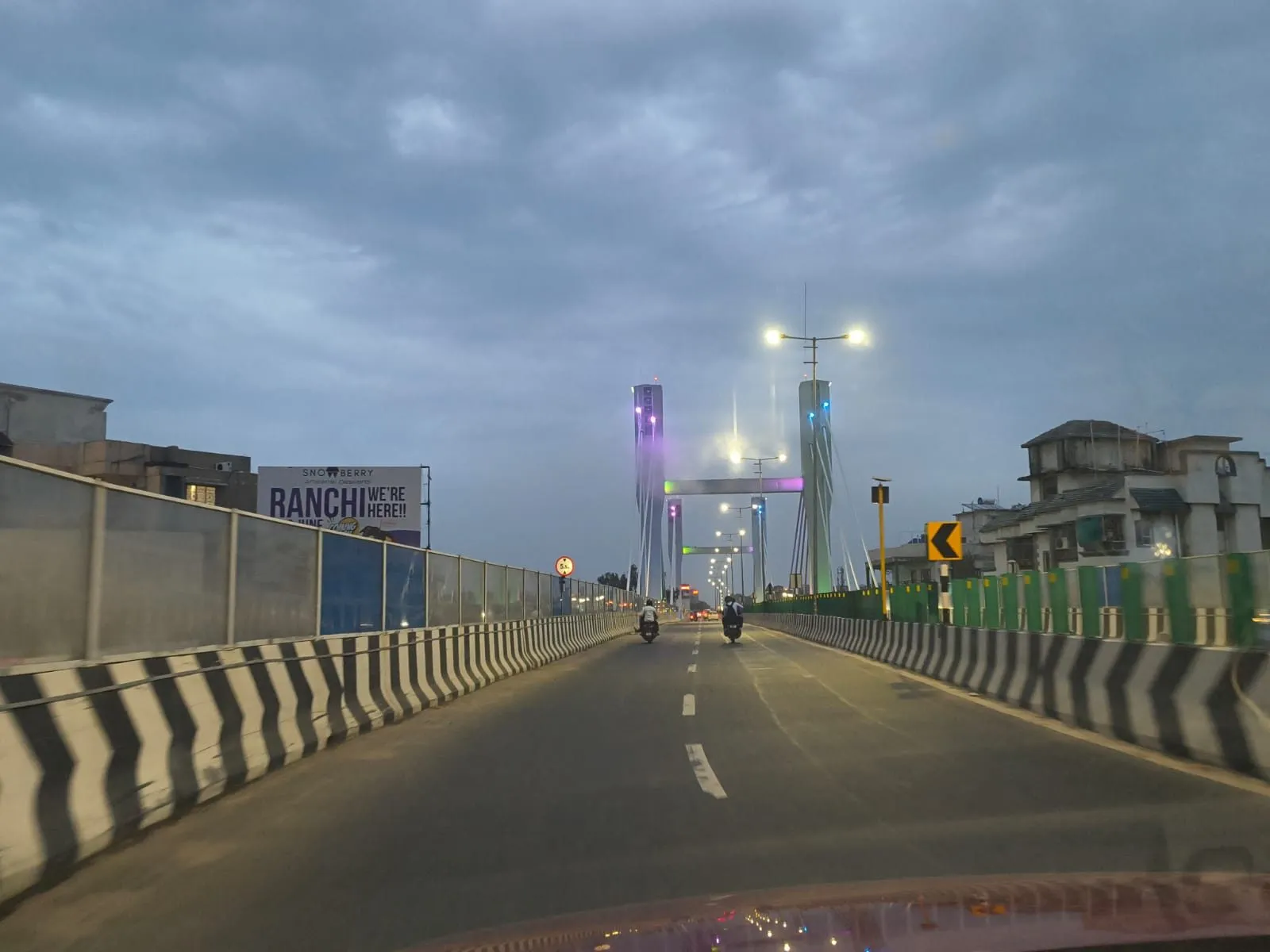 The completed flyover at dusk, its cable-stayed pylons and deck lighting energised