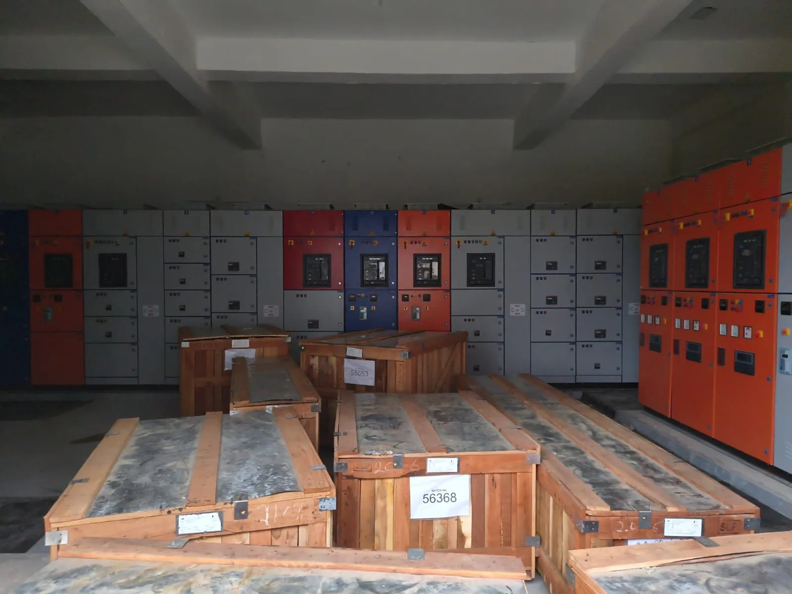 Panel room with switchgear installed along one wall and crates on the floor