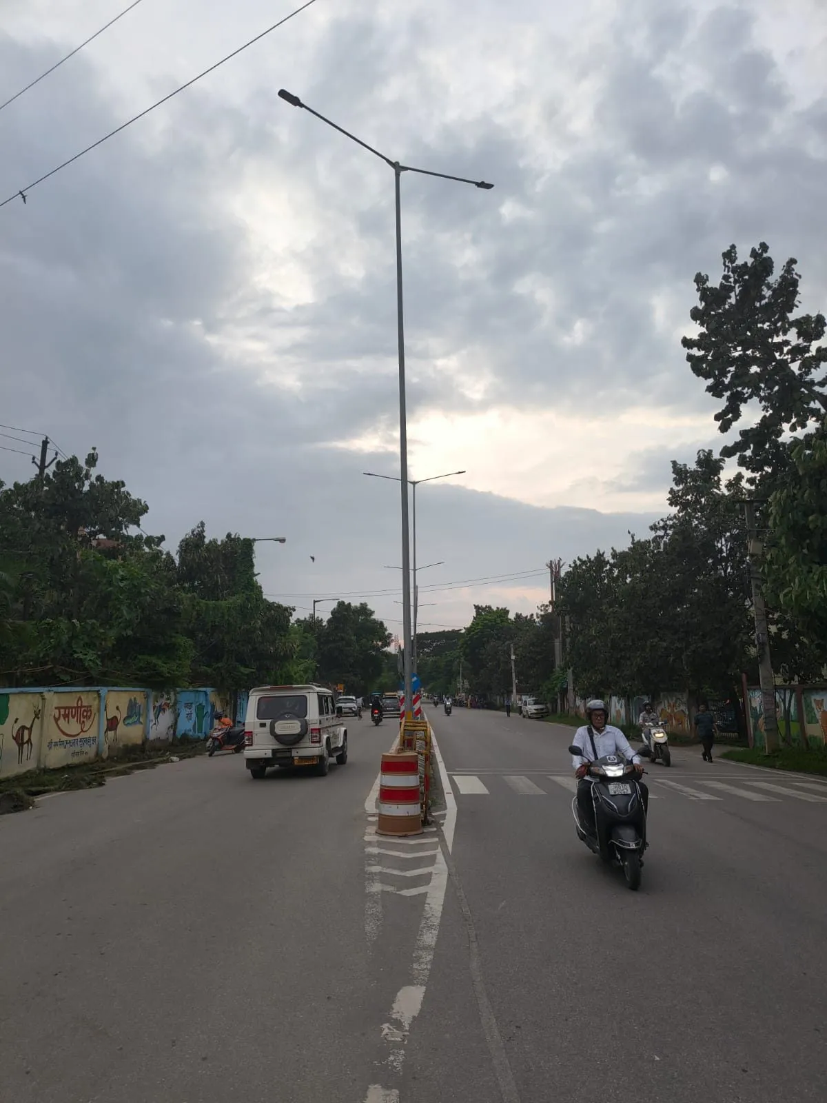 Line of street lighting poles set in the median of a two-lane road