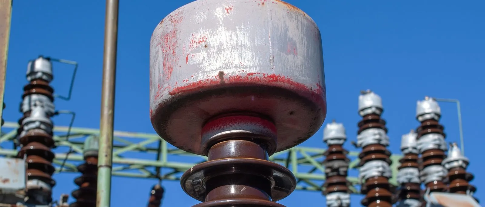 Close-up of porcelain insulator stacks in a substation switchyard
