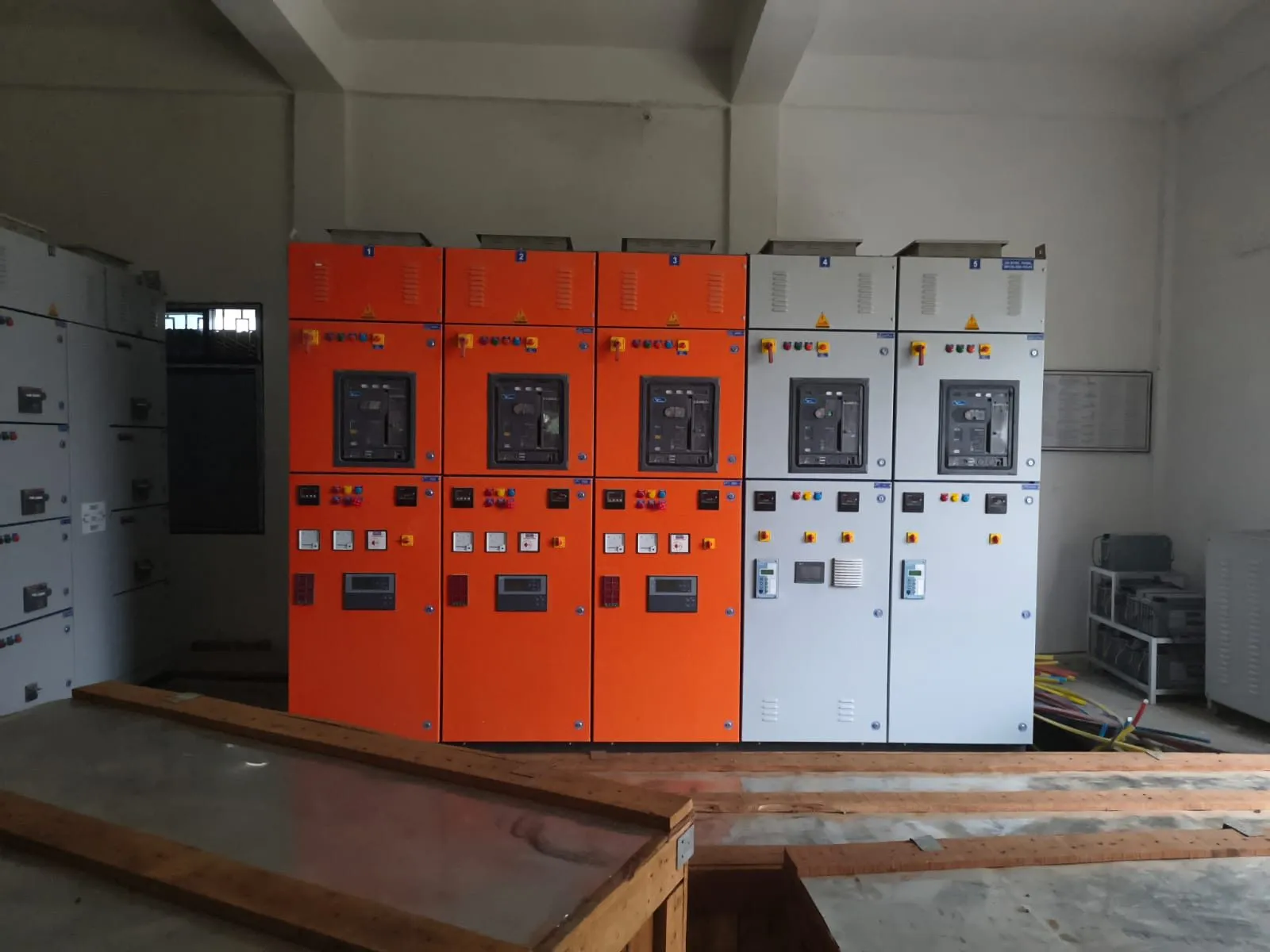 Completed switchgear line-up with orange and grey cubicles, instruments fitted