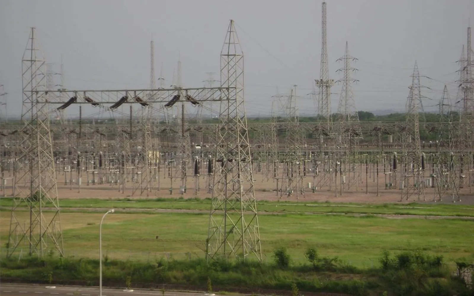A transmission switchyard of lattice gantries seen across open ground