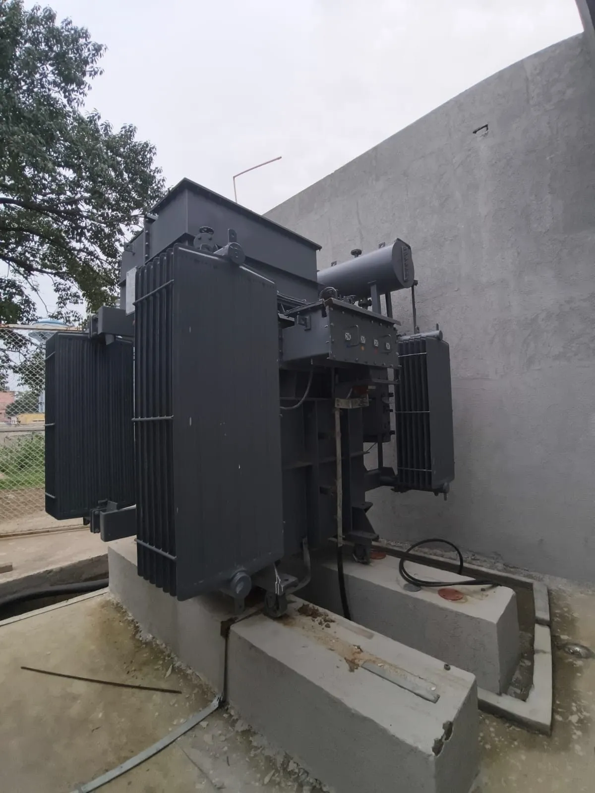 Detail of transformer radiators and tank against a substation wall
